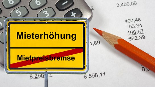 Symbolisches Ortsschild mit Mietpreisbremse