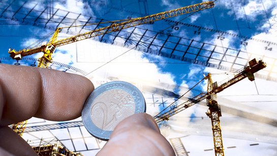 Baukran und 1 Euro Münze zur Visualisierung der Baupreisentwicklung