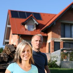 Paar vor einem neu gebauten Einfamilienhaus