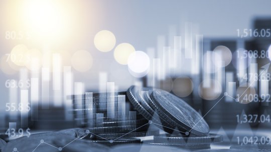 Münzen und Kurs-Charts im Gegenlicht