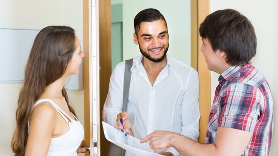 Gespräch zwischen drei Personen bei einer Wohnungsübergabe