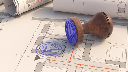 Ein Bauplan mit Baugenehmigungsstempel aus Holz