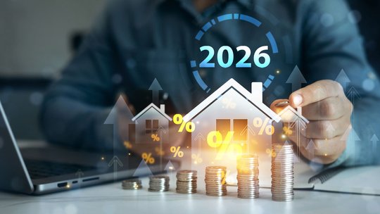 Symbolhaftes Modell eines Einfamiienhauses mit aufgereihten Münzen zur Visualisierung der Preisentwicklung im Wohnungs- und Immobiienmarkt 2026